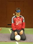 Bild zeigt Harald mit Ball hockend auf der Matte